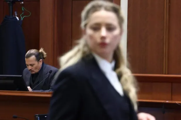 US actress Amber Heard (R) speaks to her legal team as US actor Johhny Depp (L) returns to the stand after a lunch recess during the 50 million US dollar Depp vs Heard defamation trial at the Fairfax County Circuit Court in Fairfax, Virginia, April 21, 2022. (AFP)
