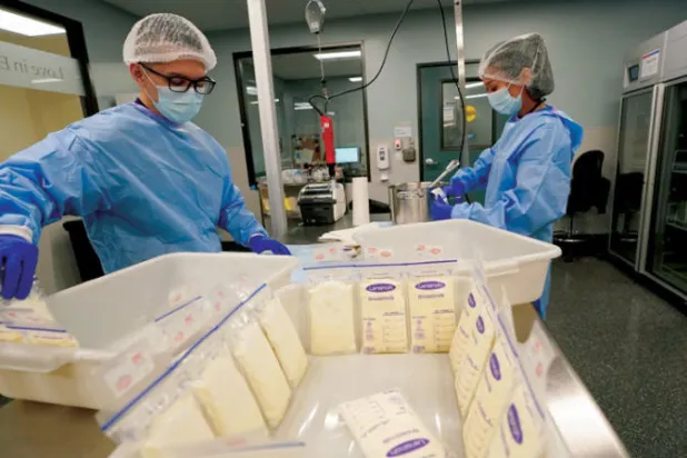 فنيّو مختبر الحليب يعملون على معالجة حليب الأمهات المتبرعات في بنك الحليب الصحي بجامعة كاليفورنيا نتيجة النقص في حليب الأطفال بأميركا للمساعدة في سد فجوة العرض (أ.ب)