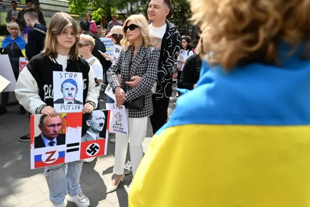 Budapeşte’de Rusya'nın Ukrayna'ya başlattığı savaşı protesto eden gösteriler sırasında Rusya Devlet Başkanı Vladimir Putin ve Nazi lideri Adolf Hitler'i bir birine benzeten bir pankartı tutan bir çocuk (AFP)