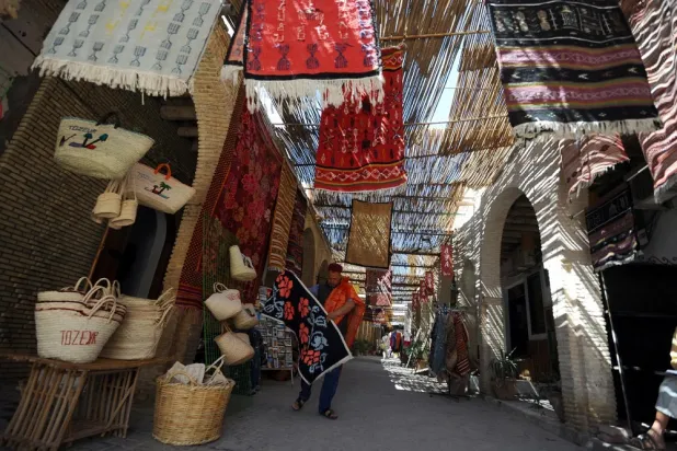 A carpet vendor displays his stock at a traditional market in Tozeur. (AFP file photo)
