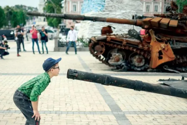 یوکرین کے ایک لڑکے کو کل کیف میں ایک نمائش میں روسی فوج کی تباہ شدہ گاڑی کی توپ کو دیکھتے ہوئے دیکھا جا سکتا ہے (رائٹرز)