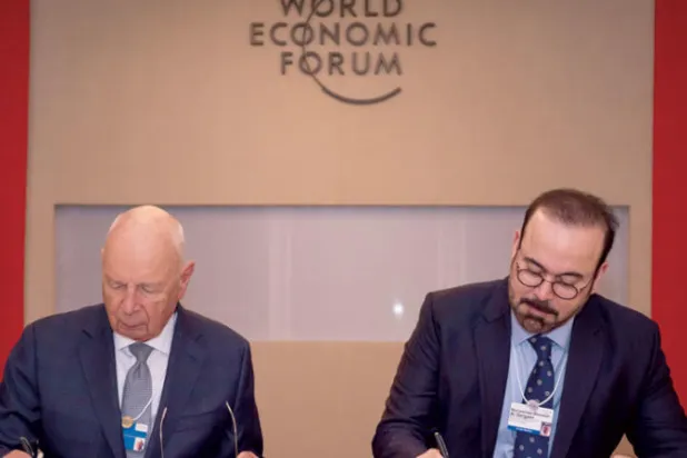 الوزير القرقاوي والبرفيسور شواب خلال توقيع الاتفاقية (الشرق الأوسط)