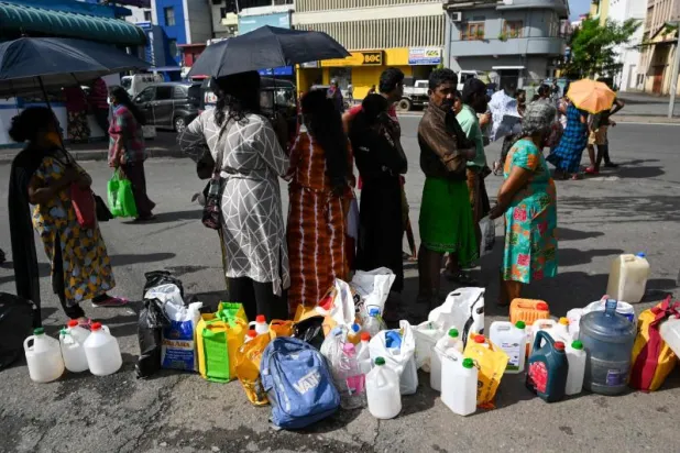 سريلانكيون ينتظرون خارج محطة وقود في كولومبو للحصول على كميات قليلة من الكيروسين (أ.ف.ب)