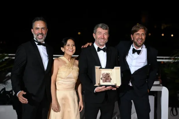 فريق عمل فيلم «مثلث الحزن» يحتفل بجائزة السعفة الذهبية (أ.ف.ب)