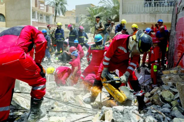 فرق الإنقاذ في موقع المبنى المنهار (رويترز)