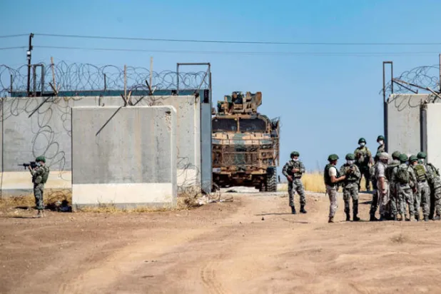 جنود روس وأتراك يتجمعون مع دخول آليات عسكرية تركية إلى سوريا للمشاركة في دورية مشتركة في ريف بلدة الدرباسية بمحافظة الحسكة على الحدود مع تركيا يوليو 2021