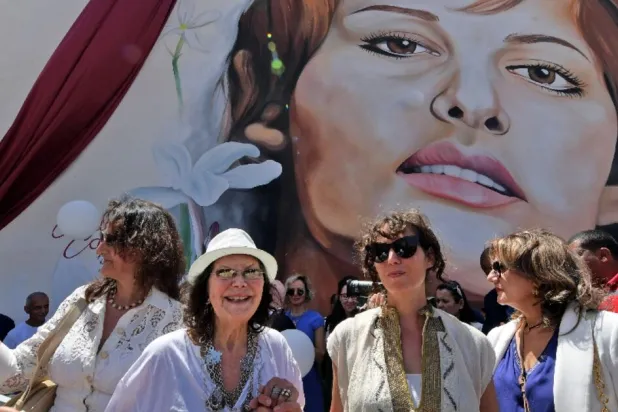 Italian-Tunisian actress Claudia Cardinale (2nd-L) poses in front of a mural of her during a street naming ceremony in her honor in Tunisia FETHI BELAID AFP
