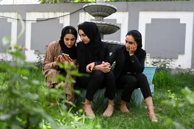 ثلاث مقدمات برامج تلفزيون في أفغانستان حيث فرضت «طالبان» على المذيعات تغطية وجوههن (أ.ف.ب)