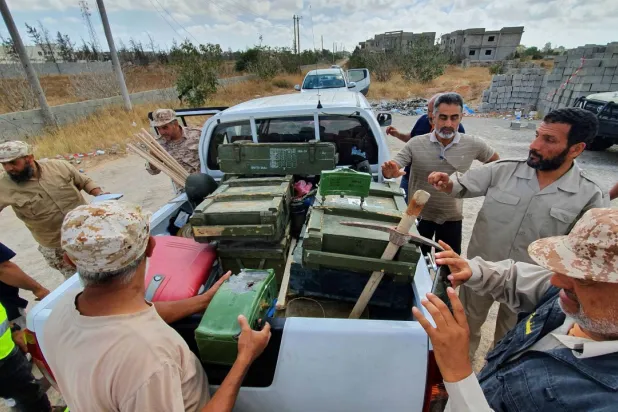 Libyan deminers stand around a pickup truck with boxes of dismantled mines and remnants of other explosives in Salah al-Din, south of the Libyan capital, Tripoli, June 15, 2020. AFP