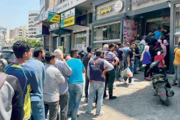 لبنانيون ينتظرون أمام أحد الأفران في بيروت (إ.ب.أ)