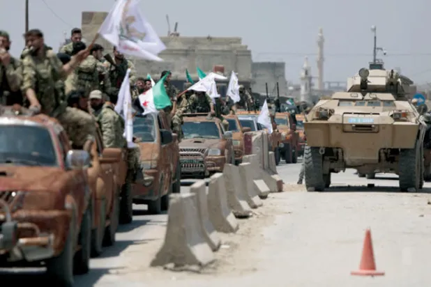 قوات من «الجيش الوطني» الموالي لتركيا في عرض عسكري بمدينة اعزاز قرب تل رفعت التي يسيطر عليها الأكراد (أ.ف.ب)