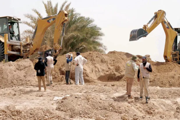 عمليات الحفر جارية في موقع مقبرة جماعية في النجف (أ.ف.ب)