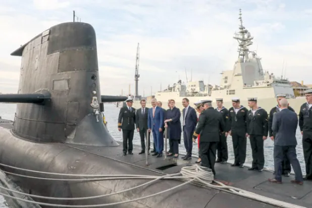 صورة تعود لعام 2018 ويظهر فيها ماكرون (الثاني من اليسار) وإلى يساره رئيس وزراء أستراليا مالكوم تيرنبال على ظهر غواصة أسترالية (أ.ف.ب)