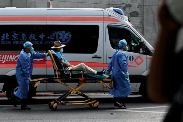 مسعفان ينقلان مصاباً بـ«كورونا» في بكين (أ.ف.ب)