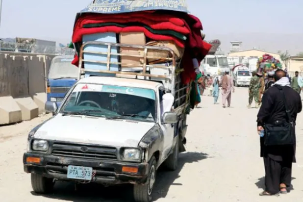 Kandahar'ın güneyindeki Spin Boldak sınır kapısı üzerinden Pakistan'dan Afganistan'a geçen aileler (EPA)