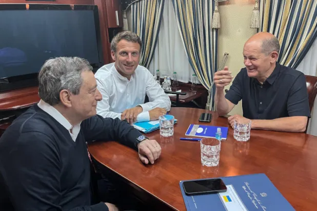 المستشار الألماني أولاف شولتس والرئيس الفرنسي إيمانويل ماكرون ورئيس الوزراء الإيطالي ماريو دراغي يجلسون داخل قطار في طريقهم إلى كييف (د.ب.أ)