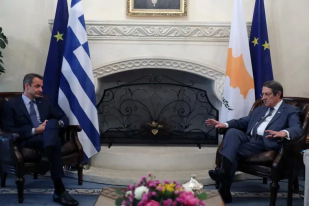 الرئيس القبرصي نيكوس أناستاسيادس (إلى اليمين) يستقبل رئيس الوزراء اليوناني كيرياكوس ميتسوتاكيس في القصر الرئاسي في نيقوسيا (رويترز)