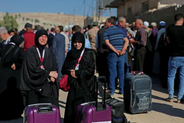 سوريون عند معبر باب الهوى يستعدون للعبور إلى تركيا أمس في طريقهم لأداء فريضة الحج (أ.ف.ب)