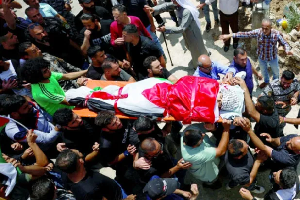 فلسطينيون يشيعون علي حرب الذي قتله مستوطن الثلاثاء (رويترز)