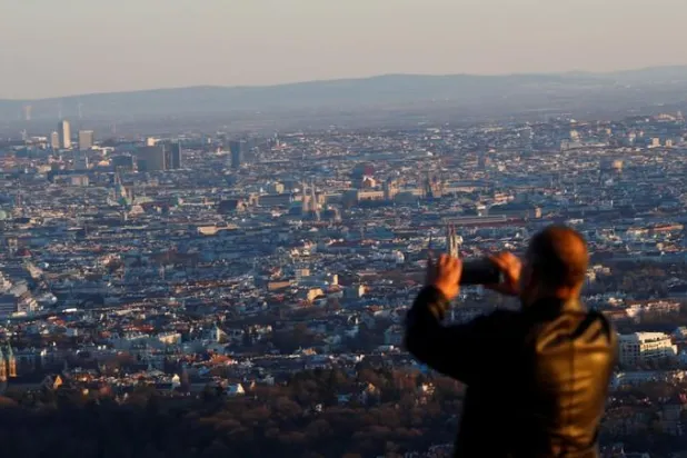 سائح يلتقط صوة لمدينة فيينا في النمسا (أرشيفية-رويترز)