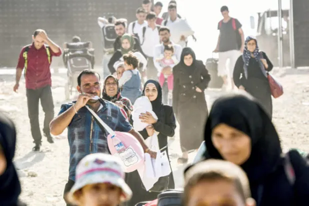 سوريون في تركيا يصلون إلى بوابة أونكوبينار قرب بلدة كيليس للعبور إلى سوريا لقضاء عطلة عيد الأضحى 2017. (غيتي)