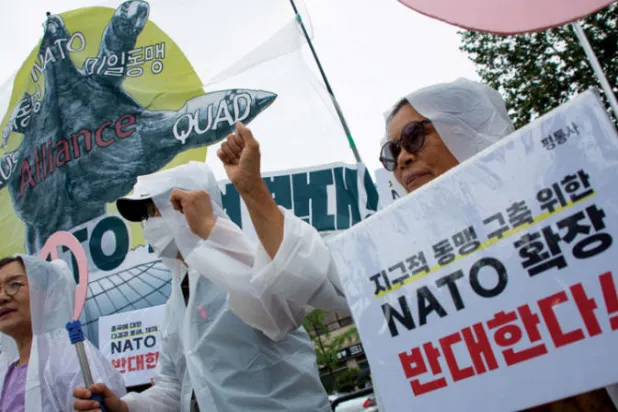 محتجون في كوريا الجنوبية أمس ضد مشاركة رئيسهم في قمة «الناتو» (إ.ب.أ)