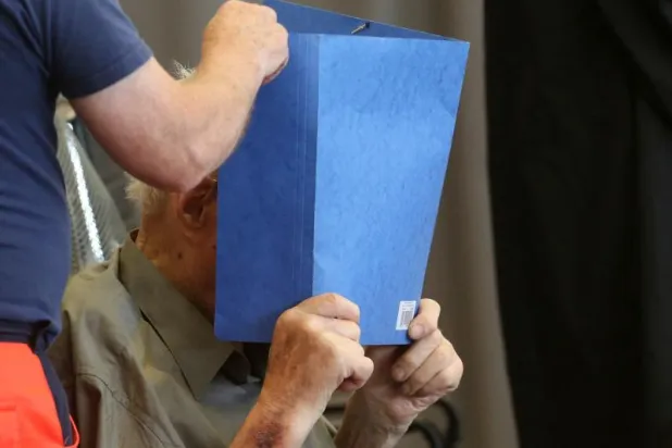 الحارس جوزيف إس يُخفي وجهه في المحكمة (أ.ف.ب)