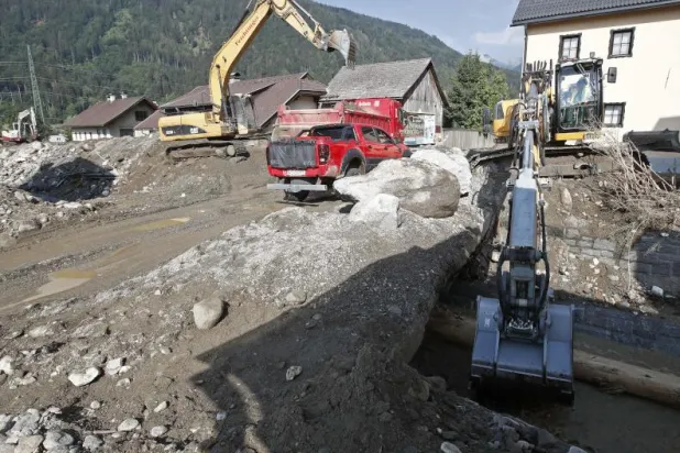 الحفارات تعمل على إزالة الطين والحطام في ولاية كارينثيا النمساوية (أ.ف.ب)