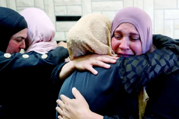 قريبات للفتى الفلسطيني محمد حامد (16 سنة) يبكينه بعد أن أُعلنت وفاته أمس (رويترز)