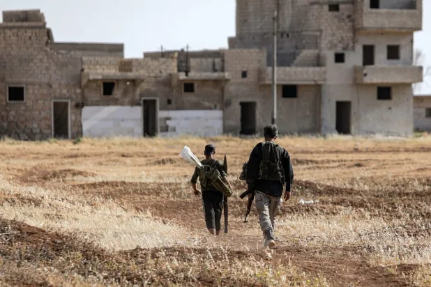 Turkish-backed Syrian opposition fighters walk at a position along the battle frontlines with the Syrian Democratic Forces (SDF) in the countryside of Syria's northern city of Manbij, on June 8, 2022. (AFP)