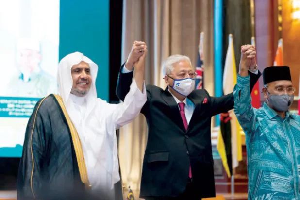 رئيس الوزراء الماليزي متوسطاً الدكتور العيسى ووزير الشؤون الدينية الماليزي (الشرق الأوسط)