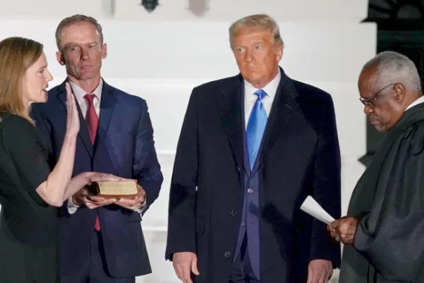 إيمي باريت تؤدي اليمين الدستورية أمام ترمب وقاضي المحكمة العليا كلارينس توماس لدى تعيينها في المحكمة عام 2020 (أ.ب)