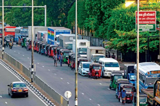 طابور على طول شارع في كولومبو أمس (أ.ف.ب) لشراء الوقود من محطة بنزين