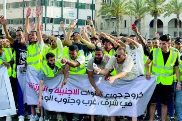 Trablus’un merkezinde düzenlenen protesto gösterisinde ‘Tüm yabancı güçler ülkenin doğusundan ve batısından ayrılsın’ yazılı bir pankart taşıyan Libyalılar (Reuters)