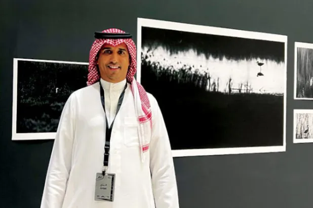 طالب المري أمام عمله المكون من 9 صور لـ«بحيرة الأصفر» (الشرق الأوسط)