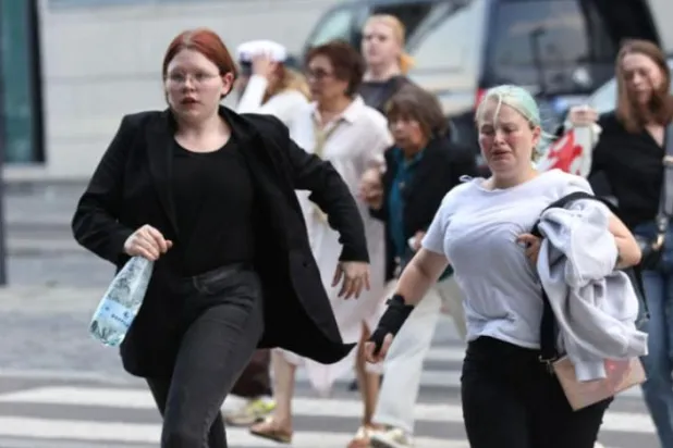 کوپن ہیگن میں گولیوں کی آوازیں سن کر شہری مال سے باہر نکل رہے ہیں (ا.ف.ب)