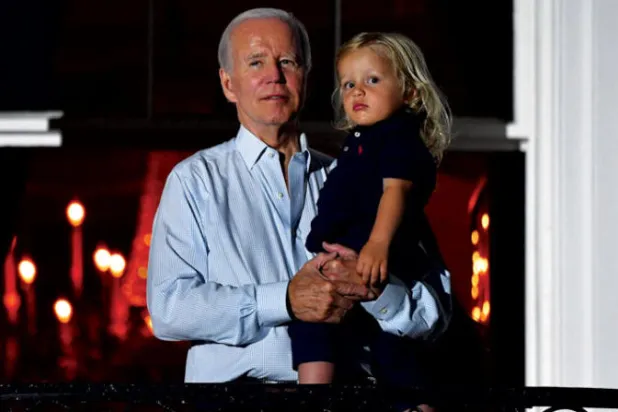 بايدن يحمل حفيده بيو بايدن خلال مشاهدته الألعاب النارية بمناسبة الاستقلال (أ.ف.ب)