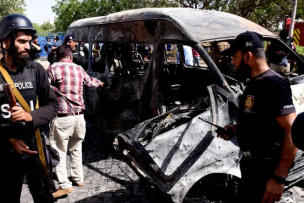 رجال شرطة باكستانيون يتجمعون بالقرب من شاحنة محترقة في موقع انفجار في كراتشي أبريل الماضي ( غيتي )