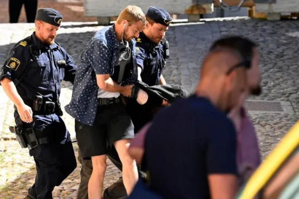 المشتبه في هجوم الطعن بجزيرة غوتلاند السويدية بعد اعتقاله (أ.ف.ب)