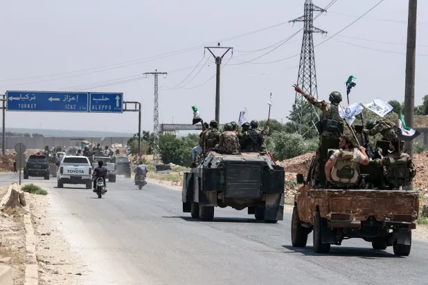 Turkish-backed Syrian opposition fighters take part in a military parade between the border towns of Qatmah and Azaz in the opposition-held northern part of the Aleppo province, on July 2, 2022. (AFP)