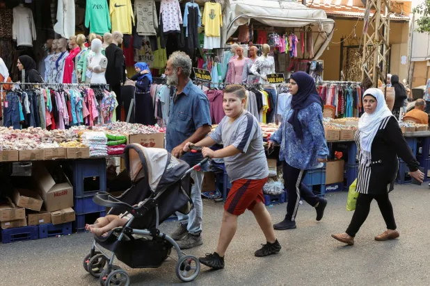 لبنانيون يبحثون عن مستلزمات عيد الأضحى في أحد الأسواق الشعبية ببيروت (رويترز)