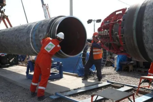 عاملان روسيان في أحد مواقع مشروع «نورد ستريم 2» في بلدة كينغيسيب الروسية (أرشيف - رويترز)