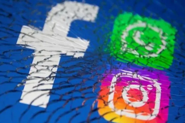 شعار منصة 'فيسبوك' يظهر الى جانب شعاري "إنستغرام' و'واتساب' خلف شاشة محطّمة (أرشيفية)