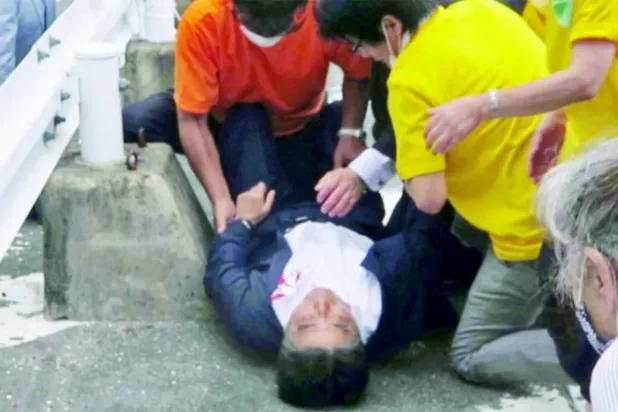 شينزو آبي ملقى على الأرض بعد إطلاق النار عليه من الخلف في مدينة نارا غرب اليابان أمس (رويترز)