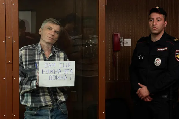 غورينوف يرفع ورقة أمام الكاميرات كُتب عليها: «هل ما زلتَ بحاجة إلى هذه الحرب؟» (رويترز)