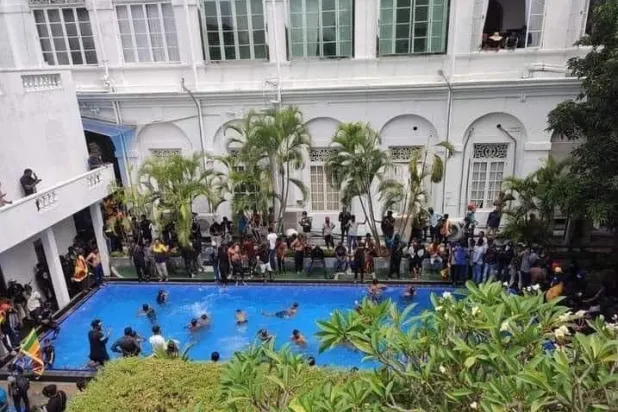 محتجون سريلانكيون في مسبح الرئيس بعد اقتحام منزله بكولومبو اليوم (تويتر)