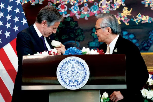 وزير الخارجية التايلندي يضع وردة على سترة نظيره الأميركي بعد توقيع مذكرة اتفاق في بانكوك أمس (رويترز)