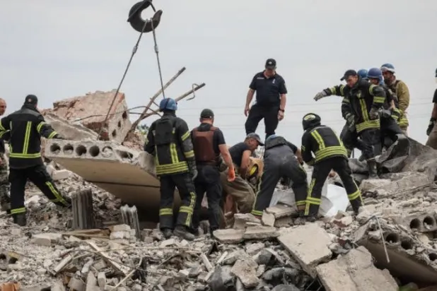 گروه های امداد رسان جسد یکی از قربانیان را از زیر آوار یک مجتمع مسکونی در دونتسک خارج می کنند (رویترز)
