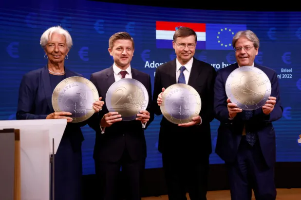 وزير المالية الكرواتي ونائب رئيس المفوضية الأوروبية ورئيسة البنك المركزي الأوروبي ومفوض الشؤون الاقتصادية بالاتحاد يقفون مع نموذج لعملة اليورو في بروكسل (رويترز)