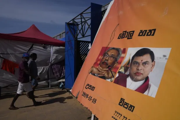 ملصق عليه صورتان واحدة للرئيس السريلانكي غوتابايا راجابكسا والأخرى لشقيقه وزير المالية السابق باسيل راجاباكسا (أ.ب)